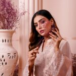 Beautiful Pakistani woman in traditional embroidered dress with floral decor and artistic composition.